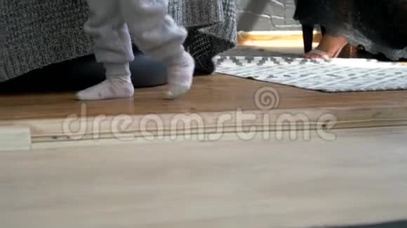 一个小孩走在地毯上的特写镜头小宝宝的脚女孩走向她妈妈第一步视频的预览图