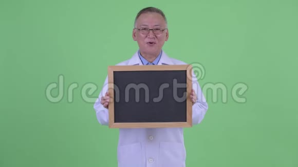 快乐成熟的日本男医生拿着黑板说话视频的预览图