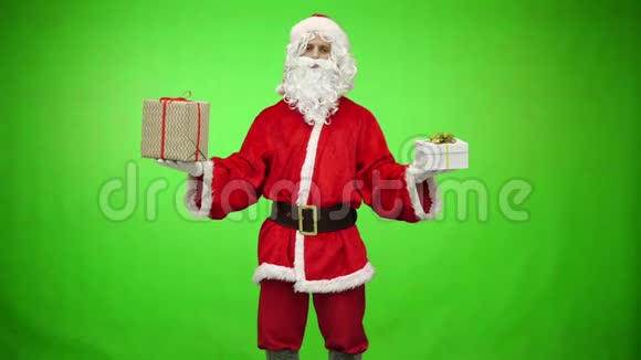 圣诞老人拿着两件绿色背景的圣诞礼物视频的预览图