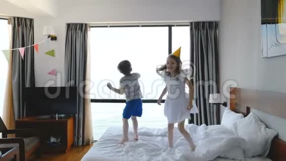 两个快乐的白种人58岁的小孩子哥哥和姐姐兴高采烈地在一个轻盈的房间里跳上床玩得很开心视频的预览图
