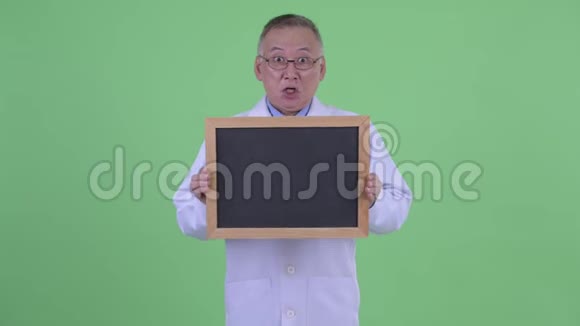 快乐成熟的日本男医生拿着黑板看着惊讶视频的预览图