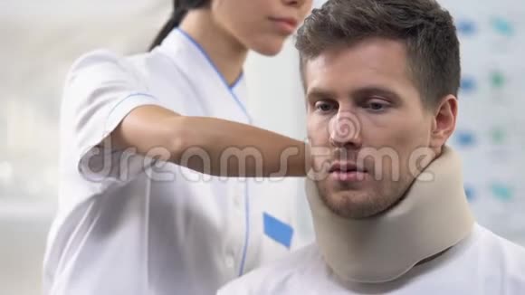 微笑护士应用烦躁男性患者泡沫颈项圈颈部损伤视频的预览图