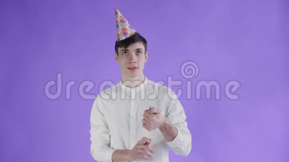 年轻人在紫色背景上爆炸纸屑饼干视频的预览图