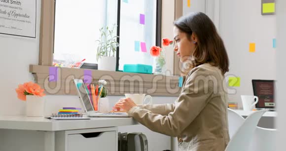 时装设计师一边喝咖啡一边工作4k笔记本电脑视频的预览图