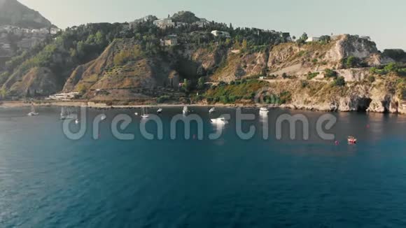 意大利西西里岛陶尔米纳2019年8月在海洋岩石海岸附近航行游艇和船只空中无人机射击视频的预览图