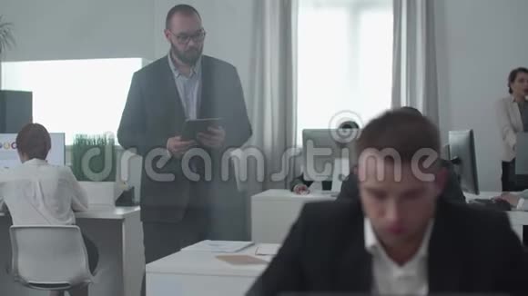 带平板电脑的头在看人们忙于工作视频的预览图