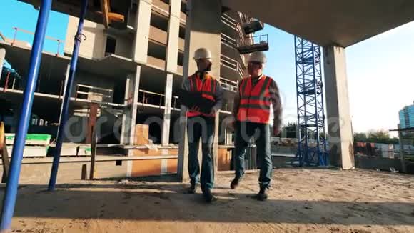男技术人员正沿着城市建筑工地行走视频的预览图