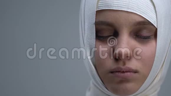 戴头巾的女人睁开眼睛看着摄像机脑外伤视频的预览图