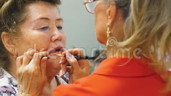 一位老年妇女正在为聚会她的朋友涂嘴唇视频的预览图