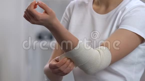 女人在疼痛的肘部关节炎疾病上穿弹性包视频的预览图