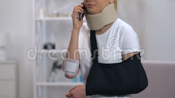 手臂吊带和颈项圈的悲伤女人在打电话感觉颈部疼痛视频的预览图