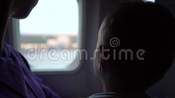 母亲带着孩子坐在飞机窗口附近等待起飞视频的预览图