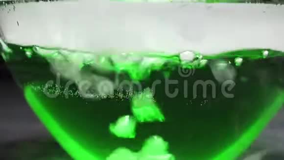 黑色背景下沸腾的绿色液体中的气体气泡视频的预览图