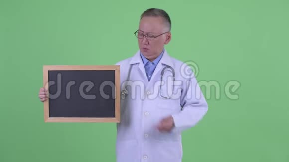 成熟的日本男医生拿着黑板竖起大拇指视频的预览图