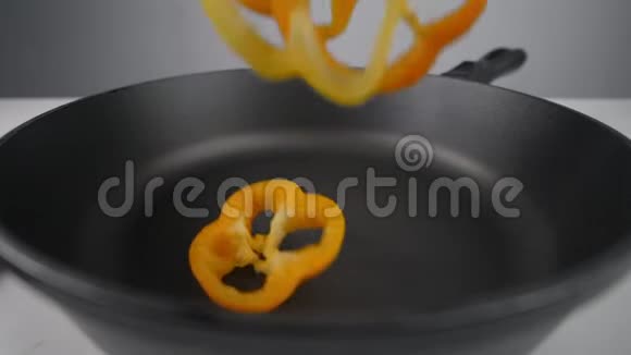 彩色的钟椒片慢慢地落在热锅上烹制素餐做炖菜视频的预览图