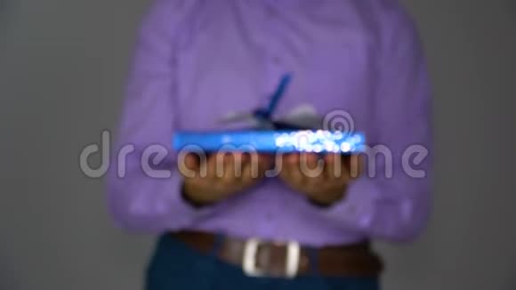 一个男人用蓝色盒子送礼物视频的预览图