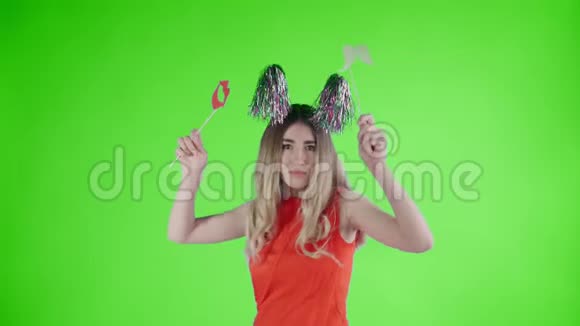 戴着派对帽的漂亮女孩正在绿色屏幕上飘落的纸屑和气球下跳舞视频的预览图