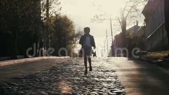 一个9岁的小女孩扎着辫子跑向广场上的铺着鹅卵石的马路上视频的预览图