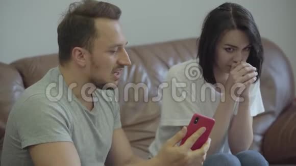 一幅愤怒的男人对妻子大喊大叫的肖像用她在家的情人的信息显示她的手机问题视频的预览图