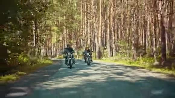 两个残暴的人骑摩托车在森林里阳光明媚的一天视频的预览图