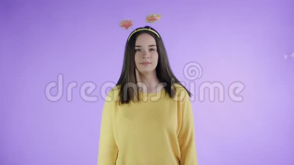 漂亮的年轻女人在紫色的背景上躲避肥皂泡视频的预览图