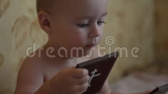 一个小孩子亲吻他手中的神的图标慢动作视频的预览图