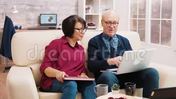 老年夫妇坐在沙发上用笔记本电脑视频的预览图