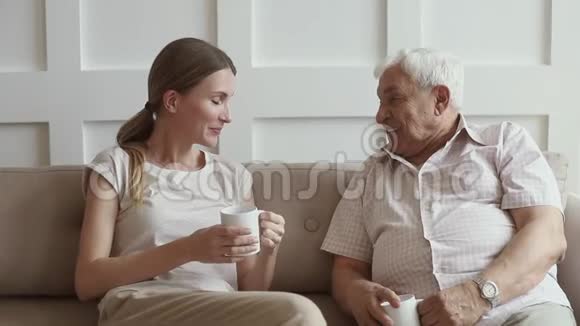 快乐的资深退休父亲和成年女儿在家聊天视频的预览图