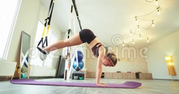 一位年轻的女性正在练习有氧运动来伸展身体她用弹力来伸展腿部视频的预览图