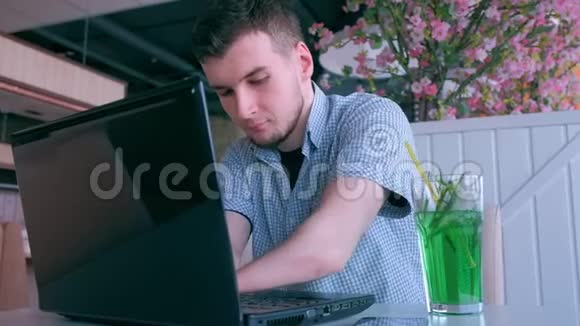 在咖啡馆里被截肢的残疾青年手在笔记本电脑上工作视频的预览图