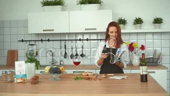 有魅力的年轻女性在家庭厨房做饭红头女近了视频的预览图
