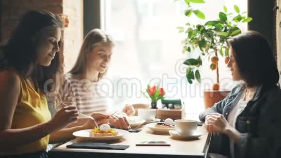 快乐的朋友在咖啡馆里吃美味的食物在餐桌上谈笑风生视频的预览图