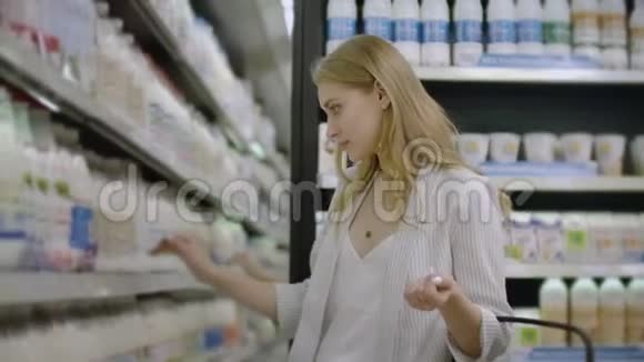 女性在杂货店选择和购买新鲜的有机乳制品视频的预览图