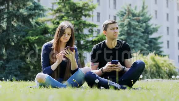 依靠电话的人在公园里使用电话严重的手机成瘾视频的预览图