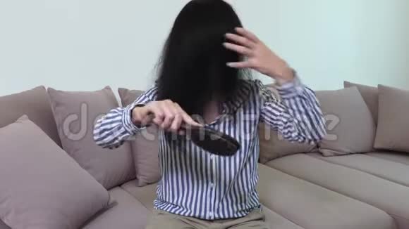 沙发上的女人梳头发视频的预览图