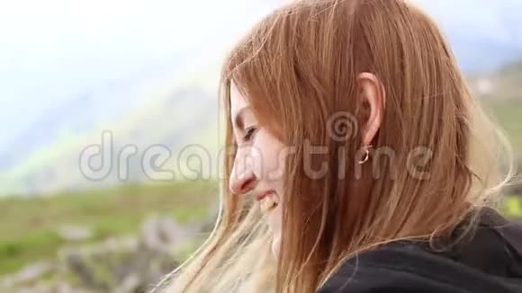 看那个女孩在一座绿色覆盖的山上看着相机视频的预览图