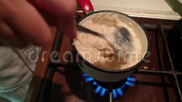 一个女人在煤气炉上煮燕麦片视频的预览图