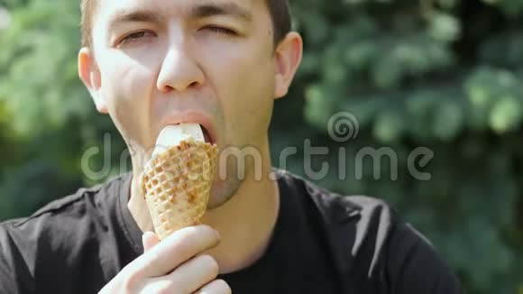 饥饿的年轻人吃冰淇淋的特写镜头视频的预览图