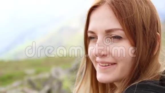 看那个女孩在一座绿色覆盖的山上看着相机视频的预览图