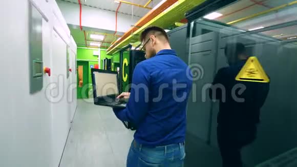 男计算机技术人员正沿着服务器单元行走视频的预览图
