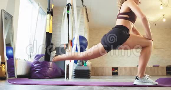 年轻女子在瑜伽工作室里用一种特殊的支撑物伸展双腿她有一种健康的生活方式穿着视频的预览图