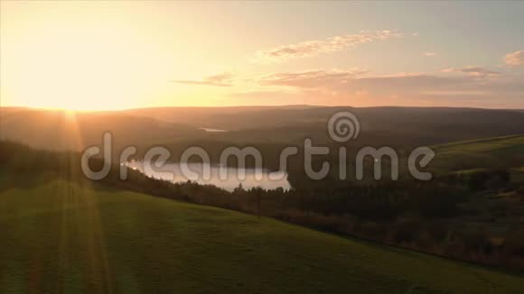在低金色夕阳下空中飞过平静的湖泊和水库英国谢菲尔德视频的预览图