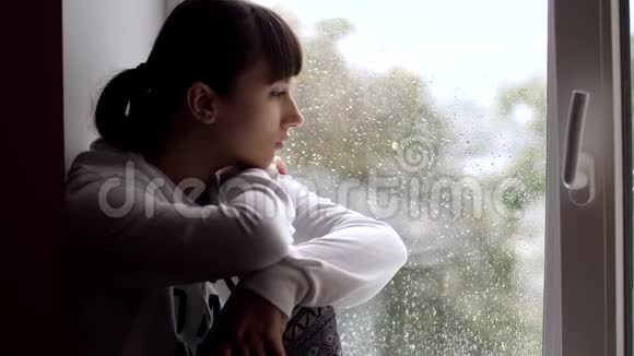 伤心的女人坐在窗台上视频的预览图