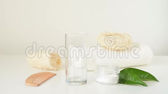 木制竹制牙刷在白色背景上落入玻璃和浴室零废品中视频的预览图