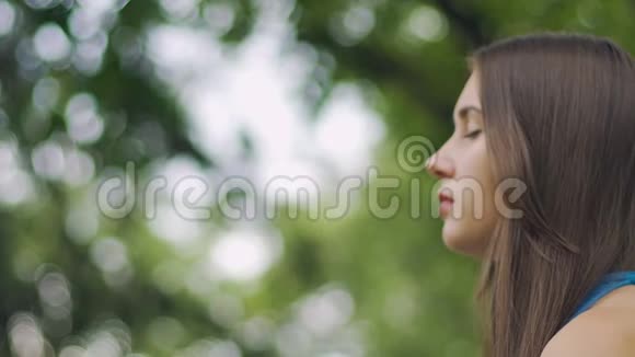 闭着眼睛的女人坐在公园里沉思禅姿合一视频的预览图