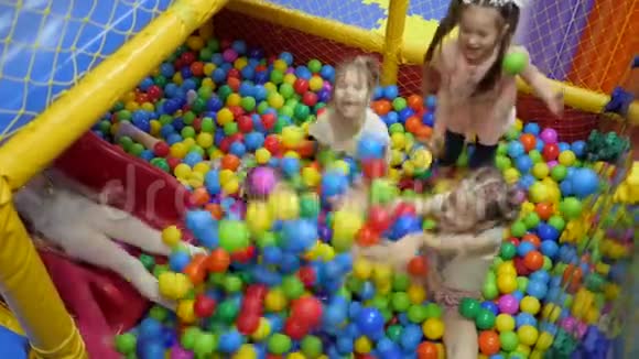 孩子们游戏室幼儿在装满塑料彩球的干盆里玩视频的预览图