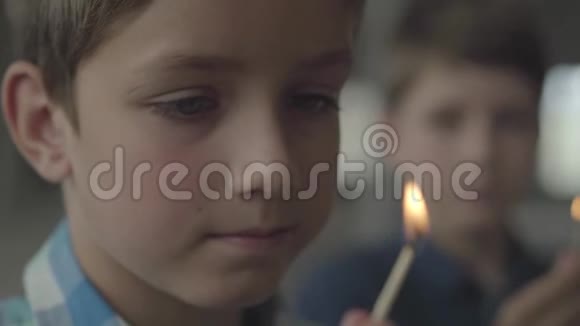 两个小弟弟在烟雾弥漫的房间里玩火的肖像特写孩子们拿出火柴看着视频的预览图