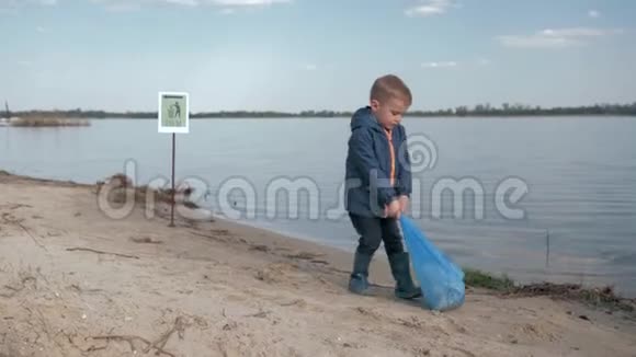 生态净化自然清理结束后小男孩在河滩的指向标志上拉了一大袋垃圾视频的预览图