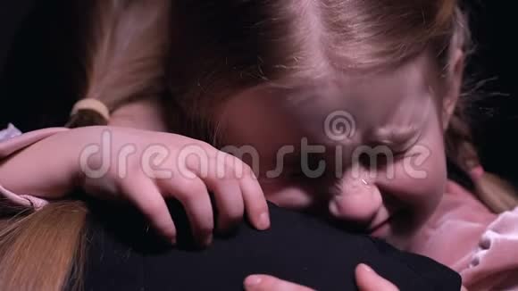 哭泣的小女孩抱着妈妈看着镜头饱受欺凌视频的预览图