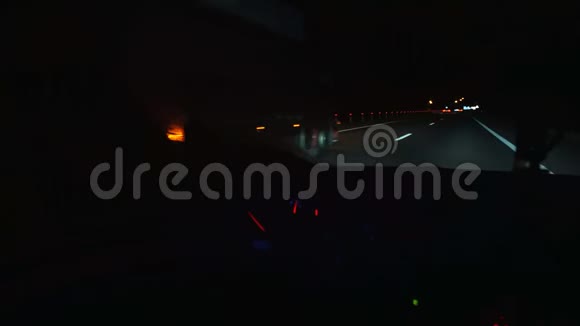晚上坐汽车夜间从高速公路的乘客室观看前照灯道路标记视频的预览图